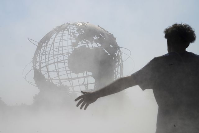 People cool off in the mist garden near the Unisphere in Flushing Meadows Corona Park, August 13th, 2021.